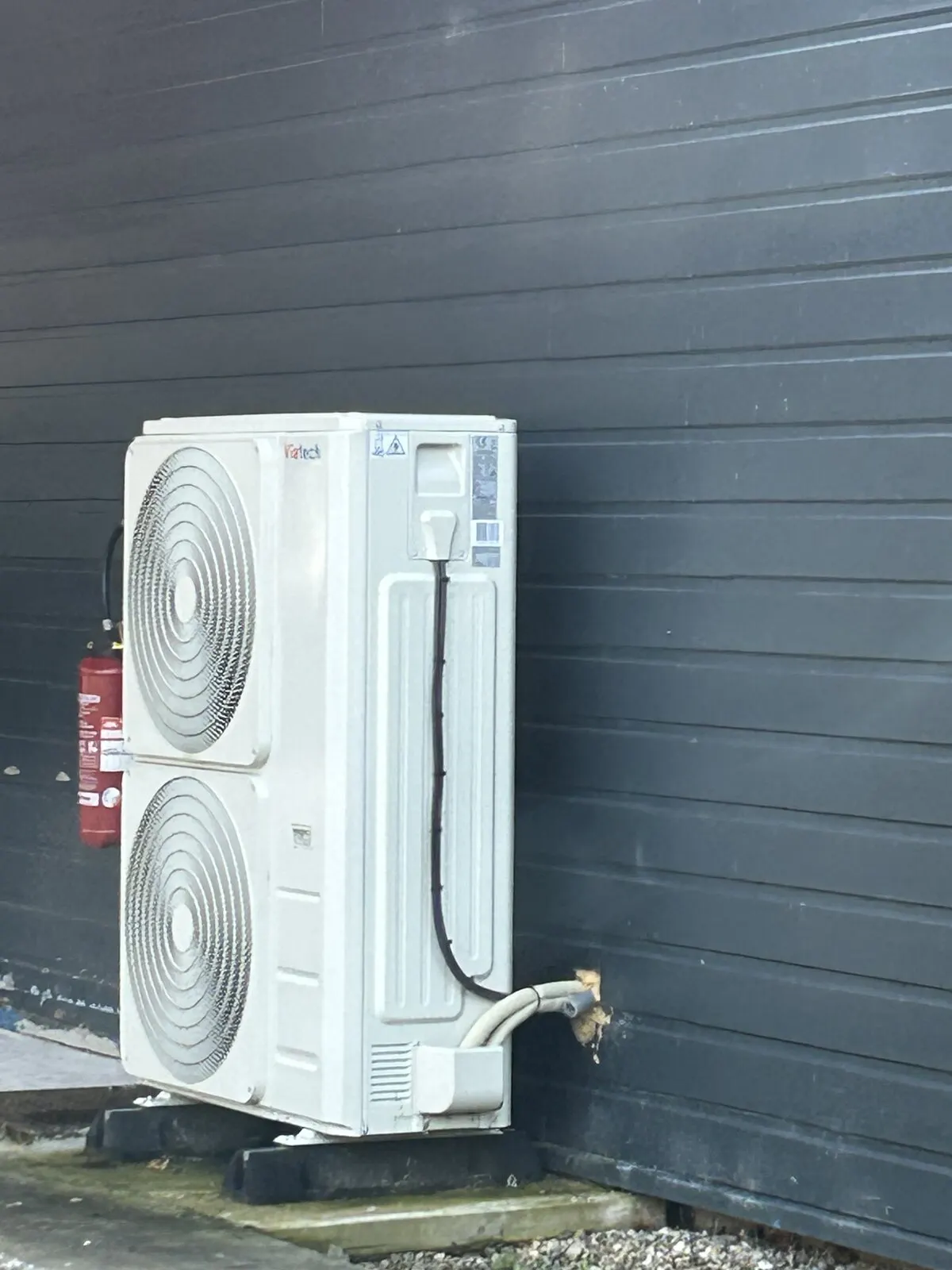 Pompe à chaleur air-eau installée par FDHE contre le bardage d’une maison de Rouen