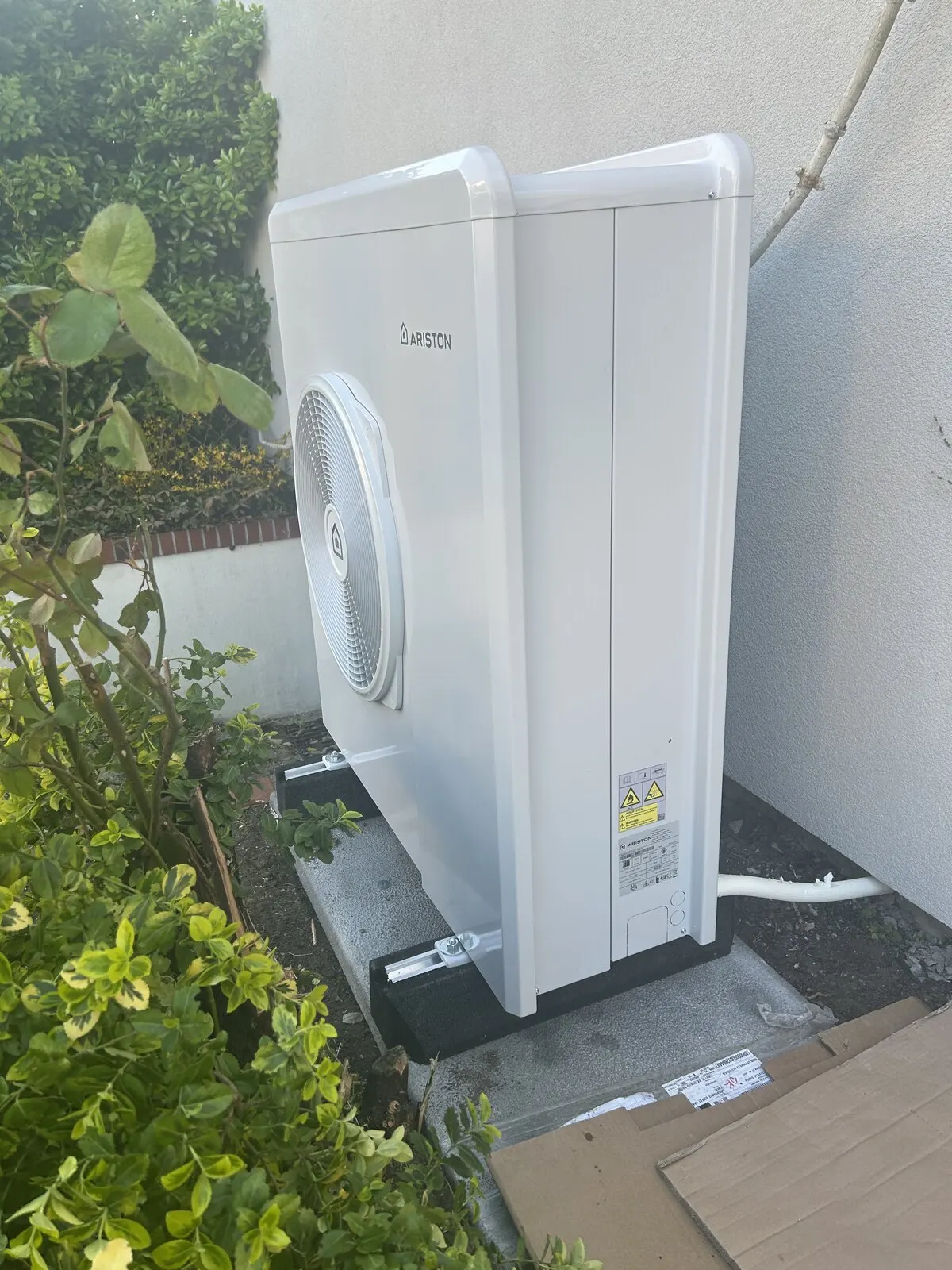 Pompe à chaleur air-eau Ariston Nimbus installée sur un muret de briques à Saint-Étienne-du-Rouvray