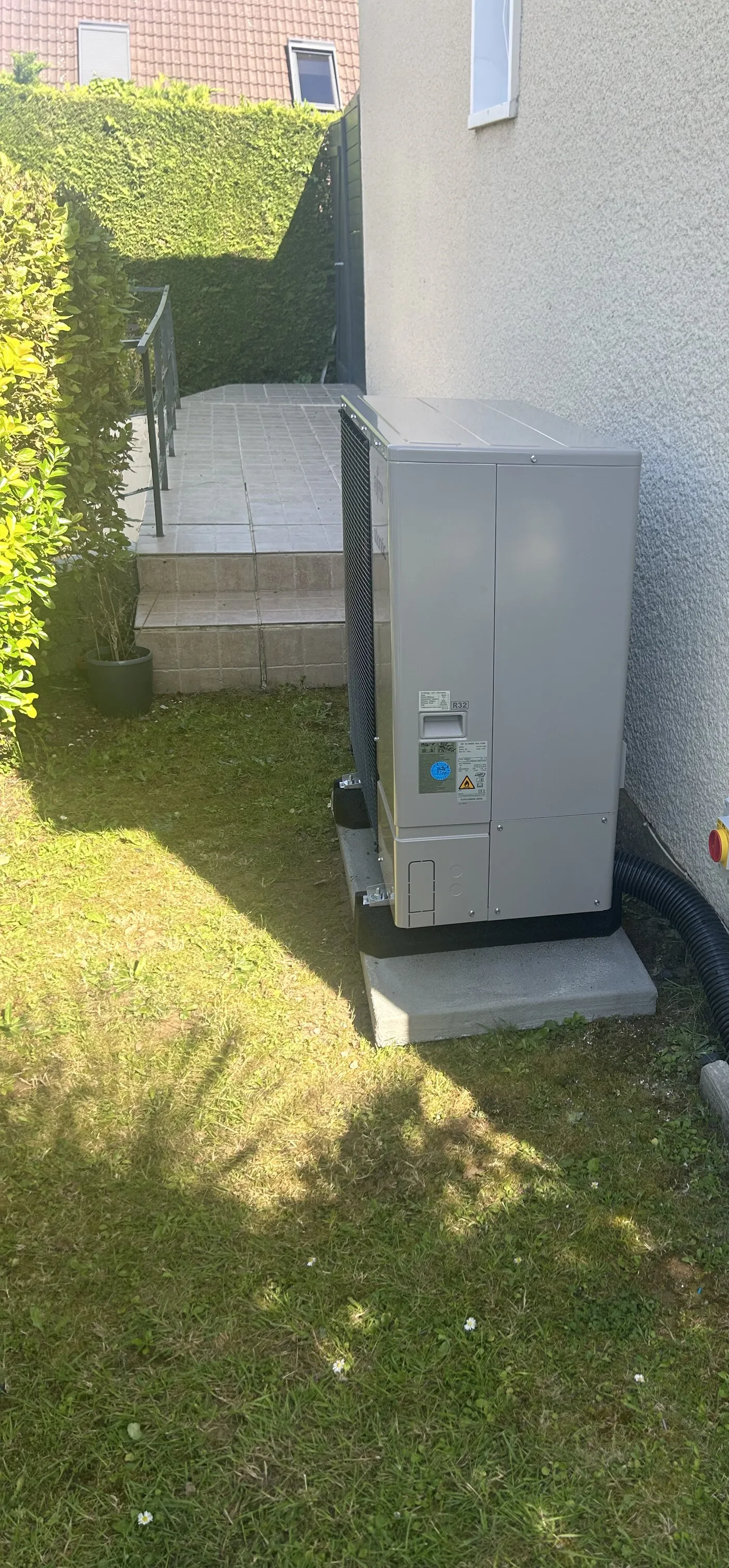 Pompe à chaleur air-eau installée par FDHE dans le jardin d’un pavillon de Saint-Étienne-du-Rouvray