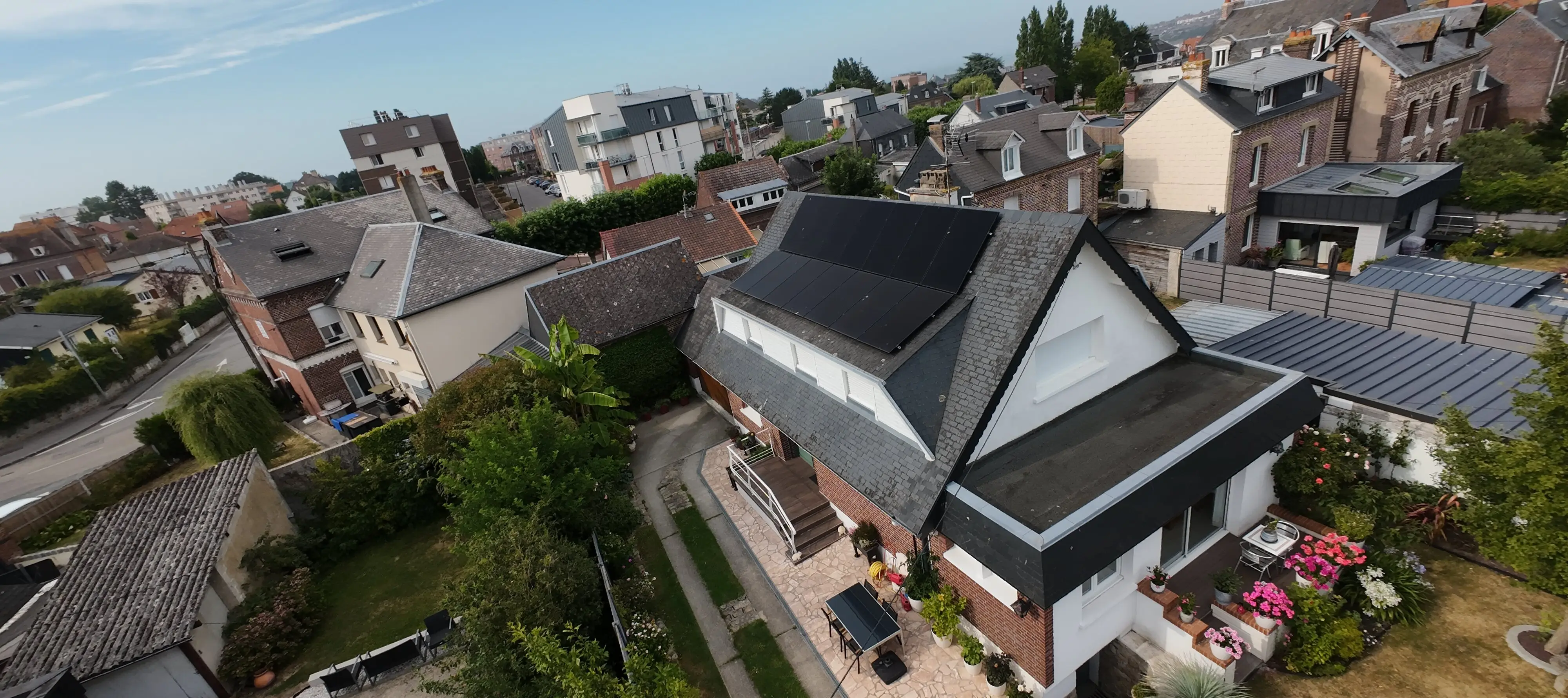 Vue aérienne d’une maison de la métropole de Rouen équipée en panneaux solaires et pompe à chaleur par FDHE